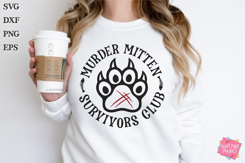 Pu&ograve; includere: Felpa bianca con un design grafico nero e rosso che dice "Murder Mitten Survivors Club". La grafica presenta un'impronta di zampa nera con segni di artigli rossi.