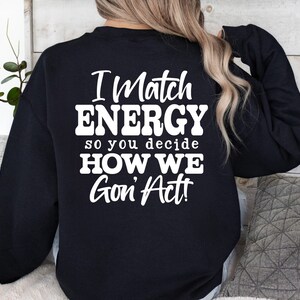 May include: Black sweatshirt with the text "I Match ENERGY so you decide HOW WE Gon' Act!" in white. The design is centered on the back of the sweatshirt. The image also includes the words "SVG DXF PNG EPS" and "DIGITAL DOWNLOAD".
