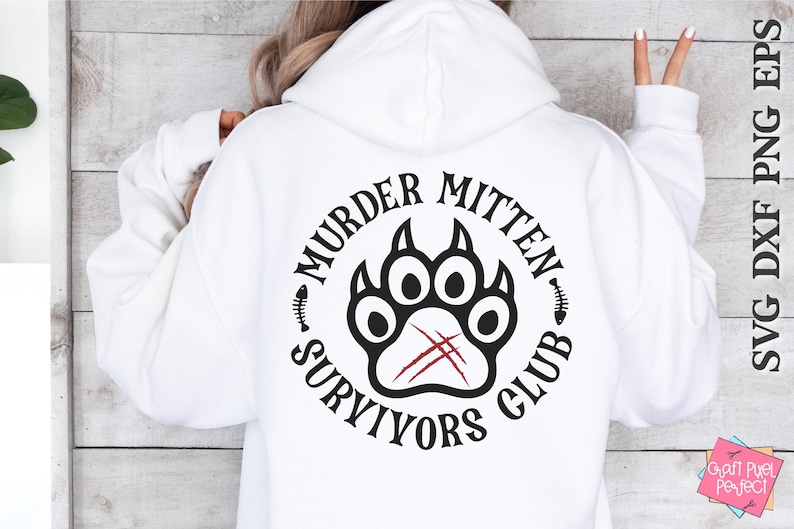 Pu&ograve; includere: Felpa bianca con un design grafico nero e rosso che dice "Murder Mitten Survivors Club" con un'impronta di zampa al centro.
