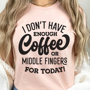 May include: A pink t-shirt with the text "I don't have enough coffee or middle fingers for today!" in black lettering.