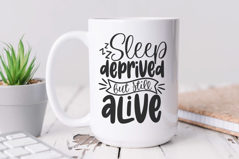 Puede incluir: Taza de cer&aacute;mica blanca con un dise&ntilde;o negro que dice "Sleep deprived but still alive".