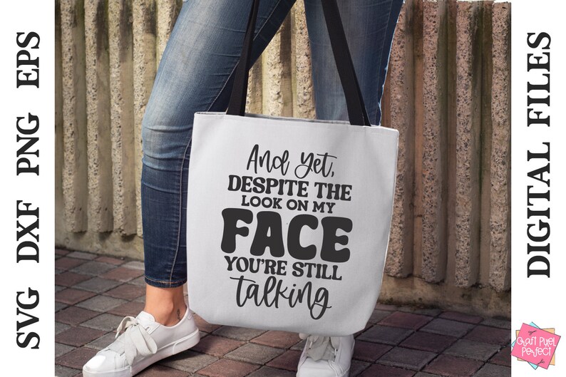 May include: A white tote bag with black text that reads "And yet, despite the look on my face you're still talking".
