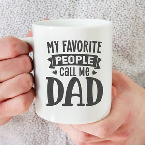 May include: White ceramic mug with black text that reads "My favourite people call me Dad".