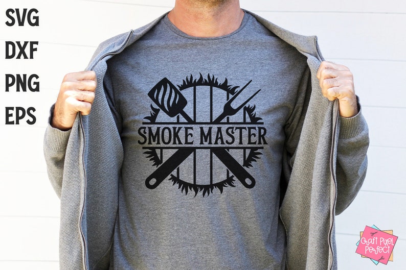 May include: A gray t-shirt with a black graphic design of a grill with crossed grilling tools and flames. The text "SMOKE MASTER" is in the center of the design.