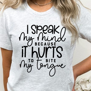 May include: A white t-shirt with black text that reads "I speak my mind because it hurts to bite my tongue".