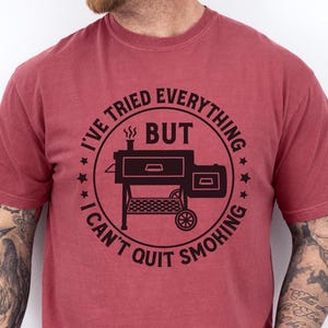 May include: A red t-shirt with a black graphic of a smoker and the text "I've tried everything but I can't quit smoking."