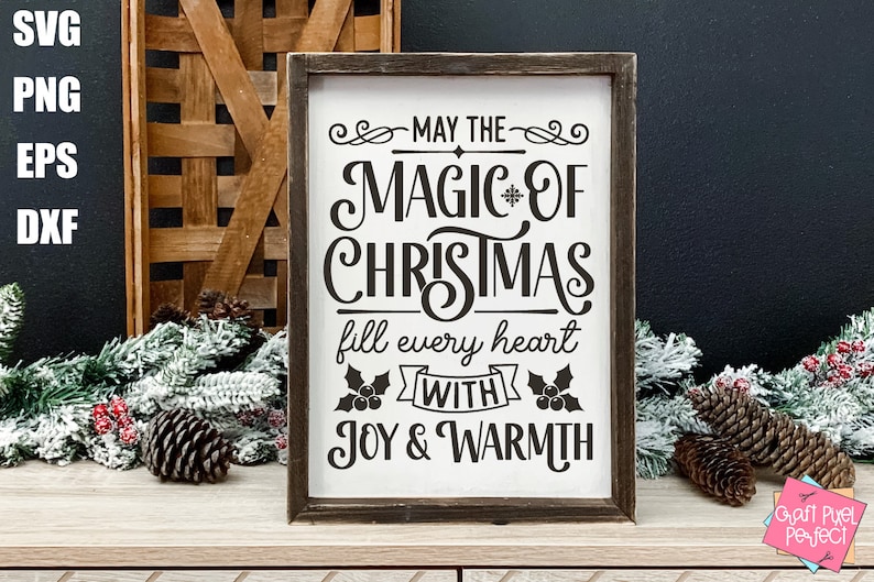 Puede incluir: Un letrero de madera con fondo blanco y texto negro que dice "Que la magia de la Navidad llene cada coraz&oacute;n de alegr&iacute;a y calidez". El letrero est&aacute; decorado con acebo y una cinta.