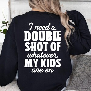 May include: A black sweatshirt with white text that reads "I need a double shot of whatever my kids are on".