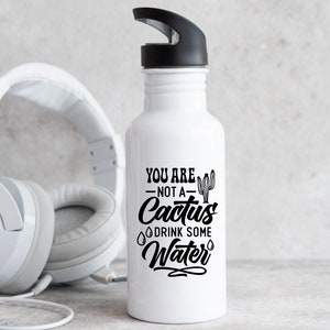 May include: White water bottle with a black lid and a black graphic that says "You are not a cactus drink some water" with a cactus illustration.