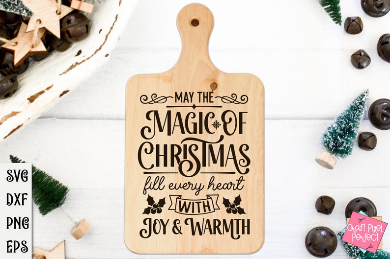 Puede incluir: Una tabla de cortar de madera con un dise&ntilde;o navide&ntilde;o. El texto dice "Que la magia de la Navidad llene cada coraz&oacute;n de alegr&iacute;a y calidez".