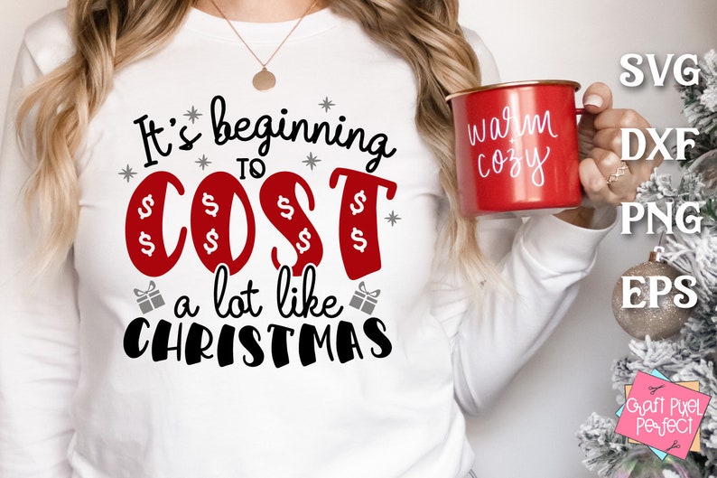 May include: White long-sleeve shirt with the text "It's beginning to cost a lot like Christmas" in black and red lettering. The word "cost" is in red and has dollar signs around it.