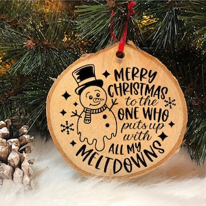 Puede incluir: Un adorno navide&ntilde;o de madera con un dise&ntilde;o de mu&ntilde;eco de nieve y el texto "Feliz Navidad al que aguanta todas mis rabietas".