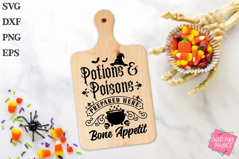Pu&ograve; includere: Un tagliere di legno con un design in bianco e nero che dice "Pozioni e Veleni Preparati Qui Buon appetito". Il design include un cappello da strega, un calderone e pipistrelli.