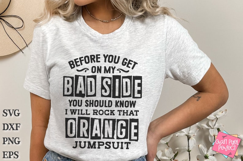 May include: A white t-shirt with black text that reads "Before you get on my bad side you should know I will rock that orange jumpsuit".