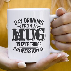 May include: White ceramic mug with black text that reads "Day Drinking From A Mug To Keep Things Professional".