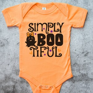 Pu&ograve; includere: Body neonato arancione con il testo "Simply Boo-tiful" in nero e un simpatico fantasma.