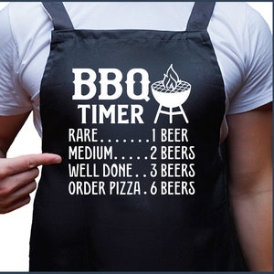 May include: A black apron with white text that reads "BBQ TIMER" and a list of doneness levels for grilling meat, with corresponding beer counts. The text reads: "RARE... 1 BEER, MEDIUM..... 2 BEERS, WELL DONE.. 3 BEERS, ORDER PIZZA. 6 BEERS".