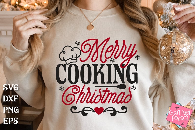 May include: A white sweatshirt with the text "Merry Cooking Christmas" in red and black lettering. A chef's hat is above the word "Cooking". A red heart is below the text.