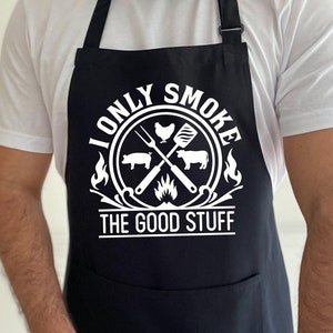 Może przedstawiać: Czarny fartuch z białym tekstem, kt&oacute;ry brzmi "I only smoke the good stuff". Tekst jest otoczony k&oacute;łkiem z grillem, kurczakiem, świnią i krową w środku.
