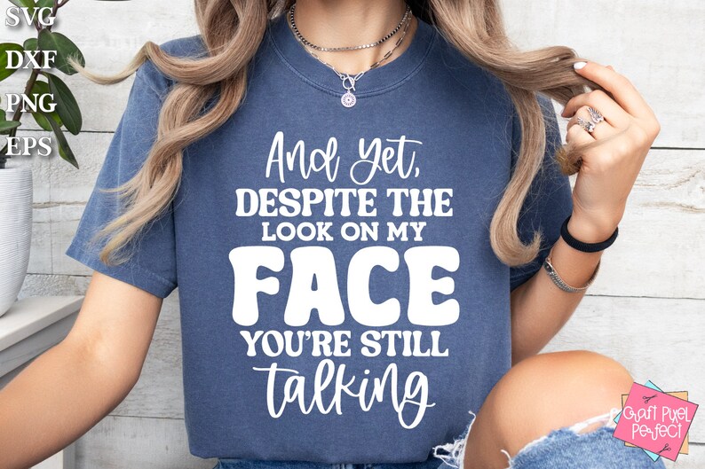 May include: A blue t-shirt with white text that reads "And yet, despite the look on my face you're still talking".