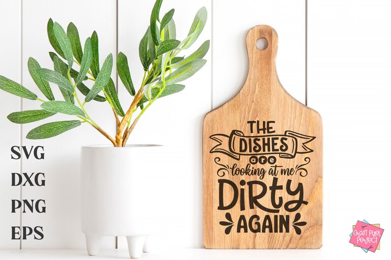 May include: A wooden cutting board with a handle, featuring the text "THE DISHES are looking at me DIRTY AGAIN" in black. A white vase with a green plant is on the left. The image also includes SVG, DXG, PNG, and EPS text.
