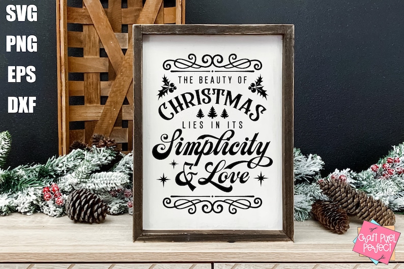 May include: A white sign with a black wood frame and the text "The beauty of Christmas lies in its simplicity & love" with a decorative border and holly sprigs.