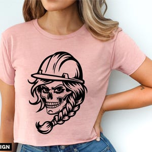 Op de afbeelding: Zwart-witte illustratie van een schedel met een helm en een vlecht. De schedel draagt een helm en heeft een vlecht. De schedel kijkt naar rechts.
