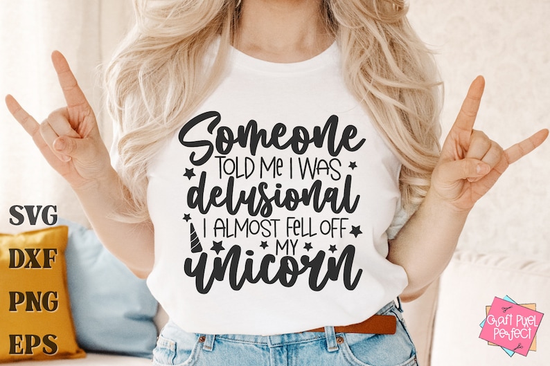 May include: A white t-shirt with black text that reads "Someone told me I was delusional I almost fell off my unicorn".