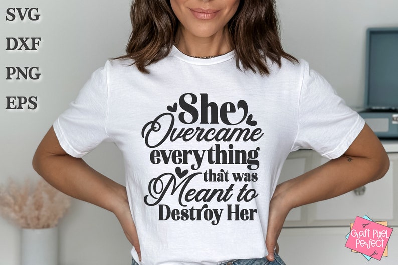 May include: A white t-shirt with black text that reads "She Overcame everything that was Meant to Destroy Her".