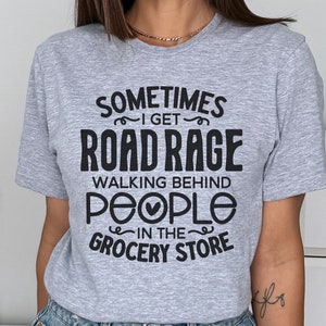 K&ouml;nnte beinhalten: Ein graues T-Shirt mit schwarzem Text, der "Sometimes I get road rage walking behind people in the grocery store" lautet.