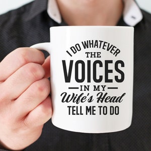May include: White ceramic mug with a black design that reads "I do whatever the voices in my wife's head tell me to do".