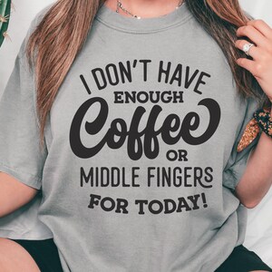 May include: A grey t-shirt with the text "I don't have enough coffee or middle fingers for today!" printed in black.