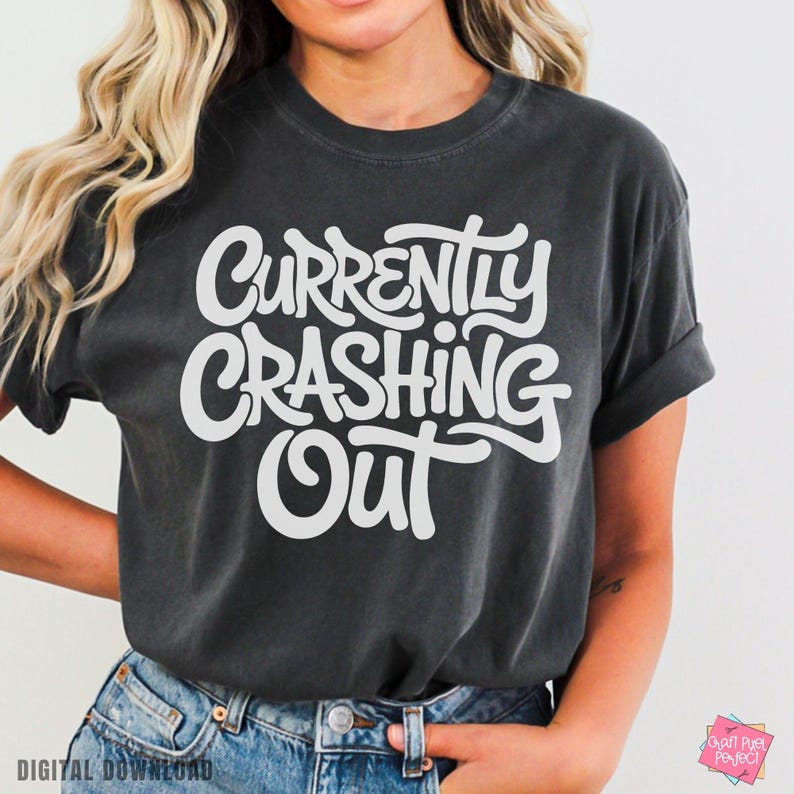 May include: Dark gray t-shirt with the white text "Currently Crashing Out" in a bold, stylized font. The shirt has short sleeves and a relaxed fit. The words "Digital Download" are at the bottom left.