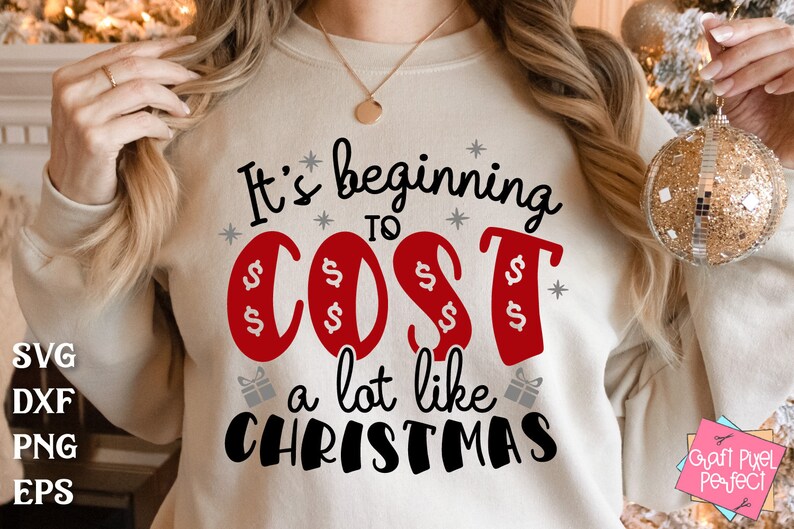 May include: A white sweatshirt with the text "It's beginning to cost a lot like Christmas" in black and red lettering. The word "cost" is in red and has dollar signs around it.