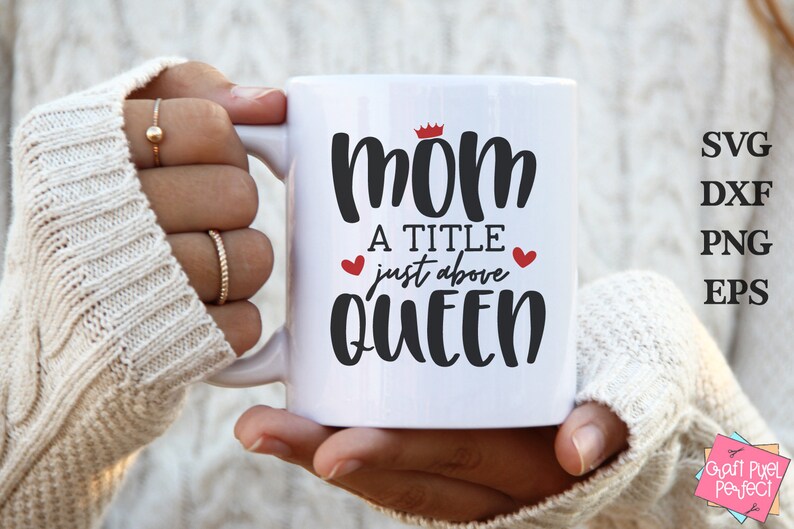 May include: White ceramic mug with a black and red design that says "Mom a title just above Queen" with a crown above the word "Mom".