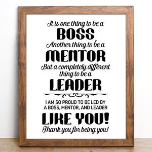 Op de afbeelding: Een ingelijst print met een zwart-wit ontwerp met de tekst "Het is &eacute;&eacute;n ding om een ​​BAAS te zijn. Een ander ding om een ​​MENTOR te zijn. Maar een compleet ander ding om een ​​LEIDER te zijn. Ik ben zo trots om geleid te worden door een BAAS, een MENTOR en een LEIDER ZOALS JIJ! Bedankt dat je jezelf bent!"