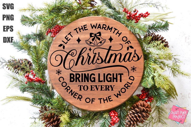May include: A round wooden sign with the text "Let the warmth of Christmas bring light to every corner of the world". The sign is decorated with holly, snowflakes, and bells. The sign is surrounded by a green Christmas wreath with red berries and pine cones.