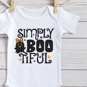 Pu&ograve; includere: Body bianco per neonato con una grafica nera e viola che dice "Simply Boo-tiful" con un fantasma dei cartoni animati che indossa un fiocco.