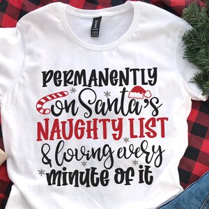 May include: White t-shirt with black text that reads "PERMANENTLY on Santa's NAUGHTY LIST & loving every minute of it". The text is decorated with a red candy cane, a red Santa hat, and snowflakes.