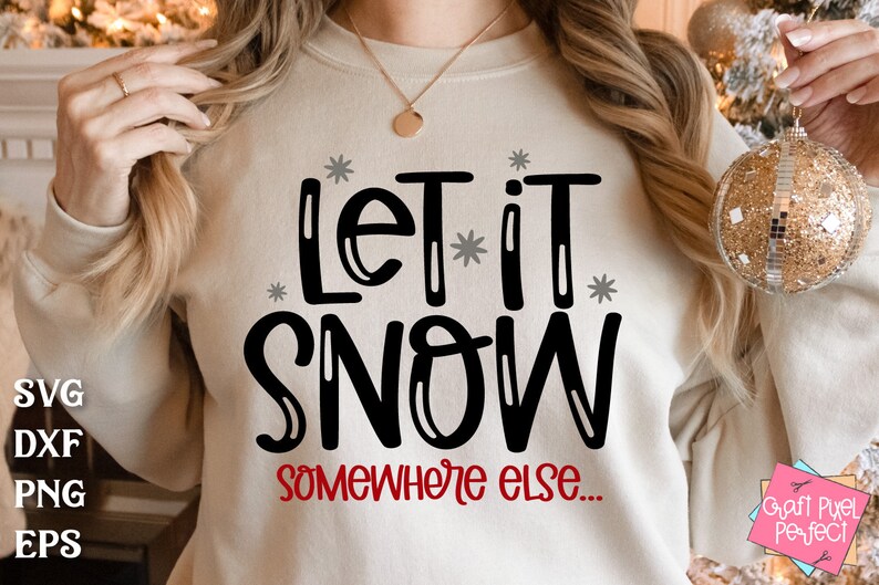 May include: A white sweatshirt with the text "Let it snow... somewhere else." in black lettering with gray snowflakes. The text "somewhere else" is in red.