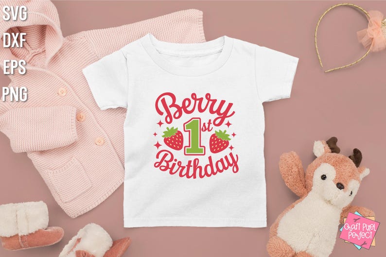 May include: White t-shirt with a red and green graphic that says "Berry 1st Birthday" with two strawberries on either side of the number one.