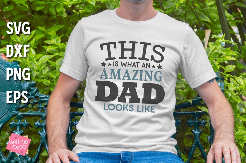May include: A white t-shirt with the text "THIS IS WHAT AN AMAZING DAD LOOKS LIKE" printed in black and blue lettering.