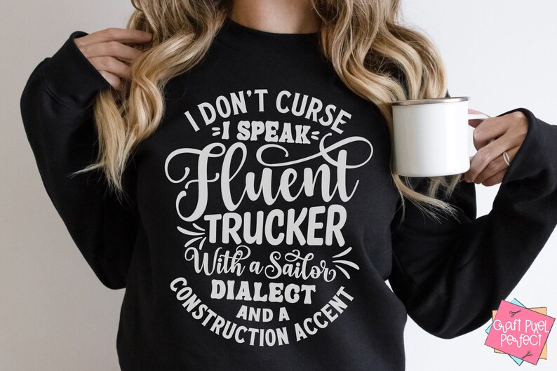 May include: Black sweatshirt with white text that reads "I don't curse - I speak fluent trucker with a sailor dialect and a construction accent".
