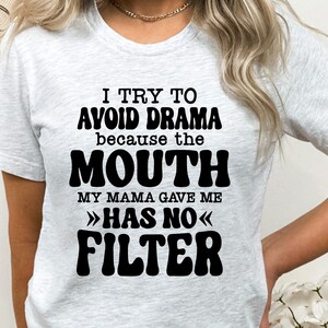 May include: A white t-shirt with black text that reads "I try to avoid drama because the mouth my mama gave me >>has no<< filter".