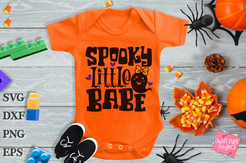 May include: Orange baby onesie with the text "Spooky Little Babe" in black with a purple heart and a ghost with a bow.