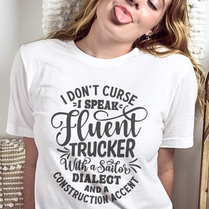 May include: White t-shirt with a black graphic that reads "I don't curse - I speak fluent trucker with a sailor dialect and a construction accent".