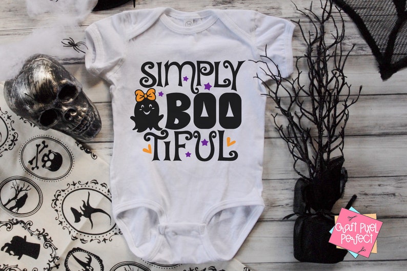 Pu&ograve; includere: Body bianco per neonato con una grafica in bianco e nero che dice "Simply Boo-tiful" con un simpatico fantasma con un fiocco.