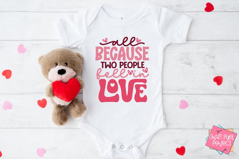 May include: White baby onesie with pink lettering that reads "all because two people fell in love".