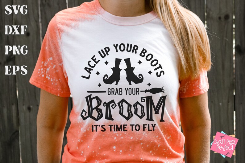 May include: A white t-shirt with an orange ombre design featuring a black graphic that says "Lace Up Your Boots Grab Your Broom It's Time To Fly" with a witch's hat and broom illustration.