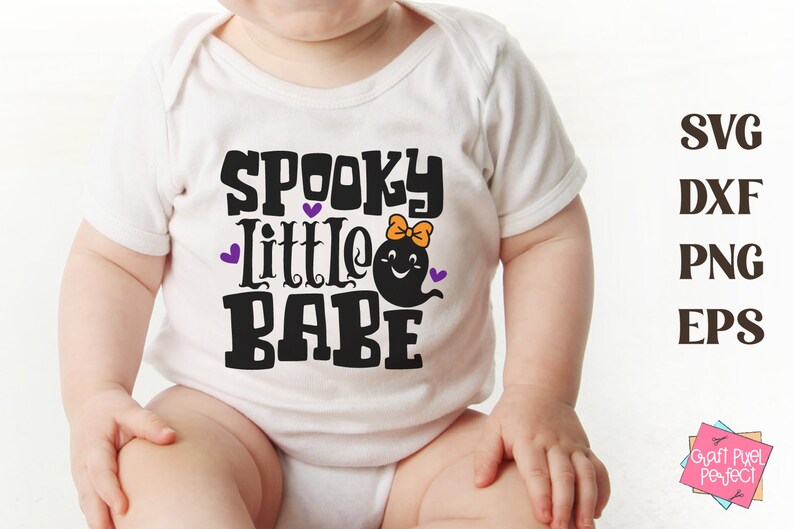 May include: A white baby onesie with the text "Spooky Little Babe" in black. A purple ghost with a pink bow is next to the text.